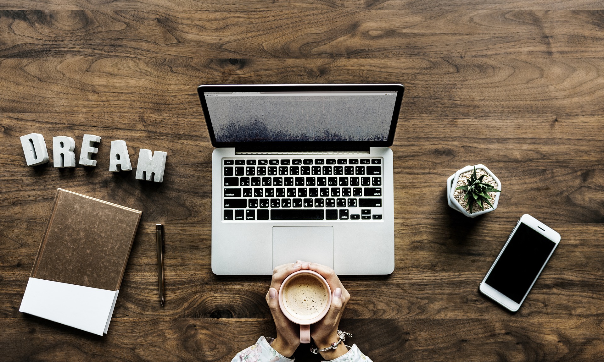 Running a Business from home, laptop coffee and words dream on a desk