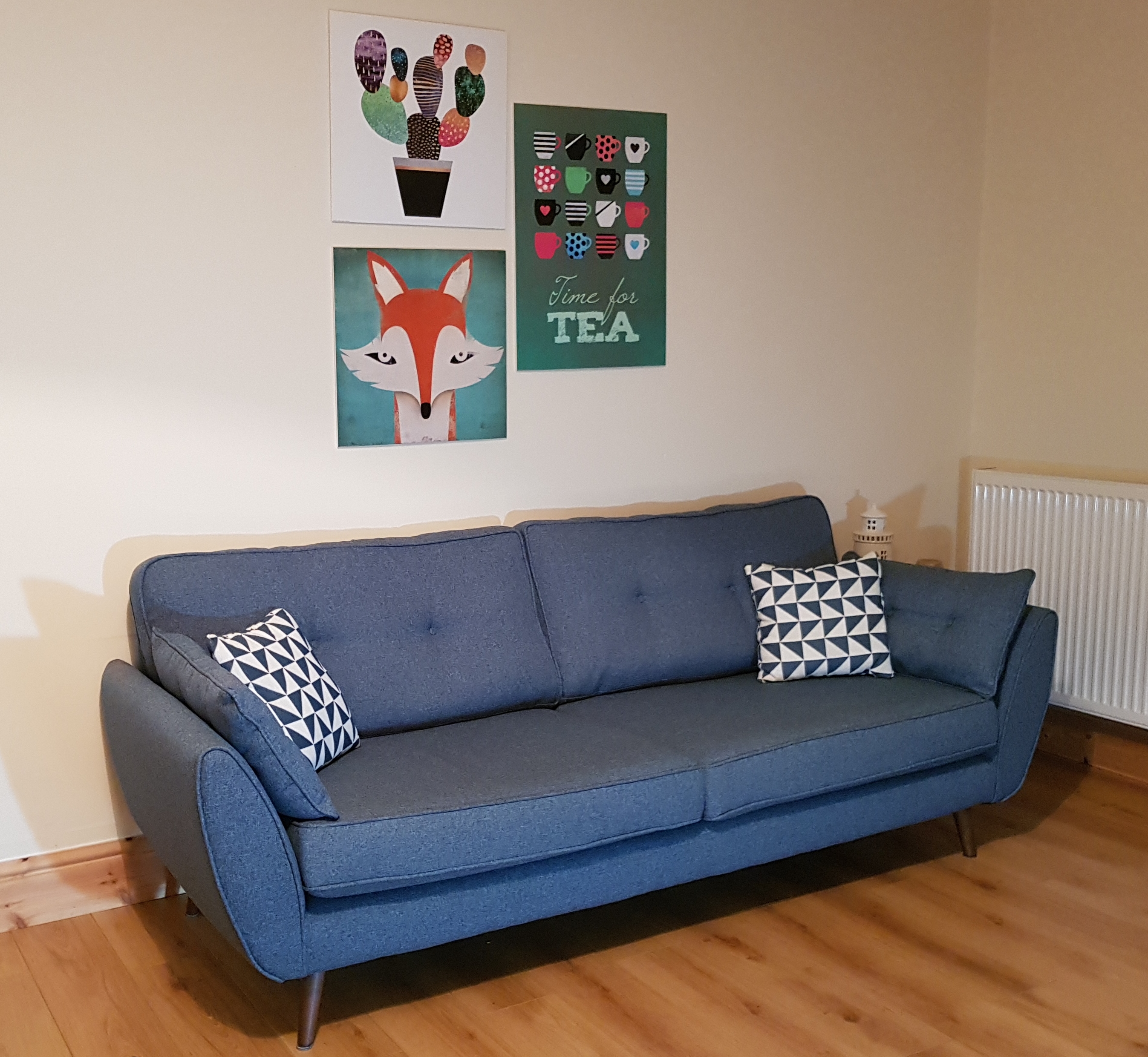 Teal sofa with pictures above