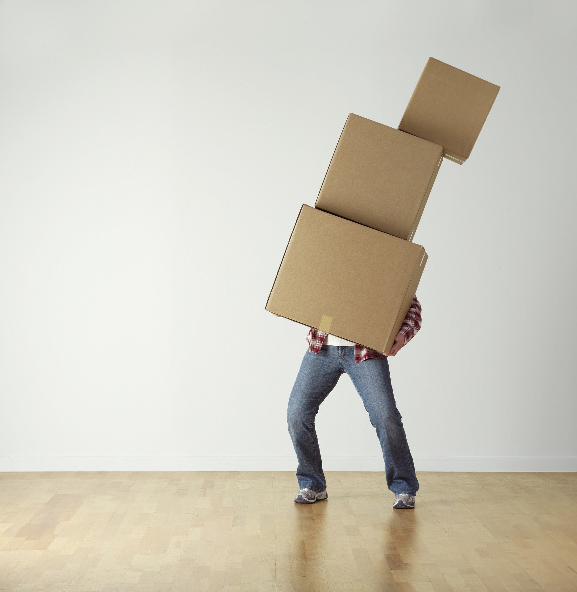 Man Holding three cardboard boxes that are leaning over for Moving House