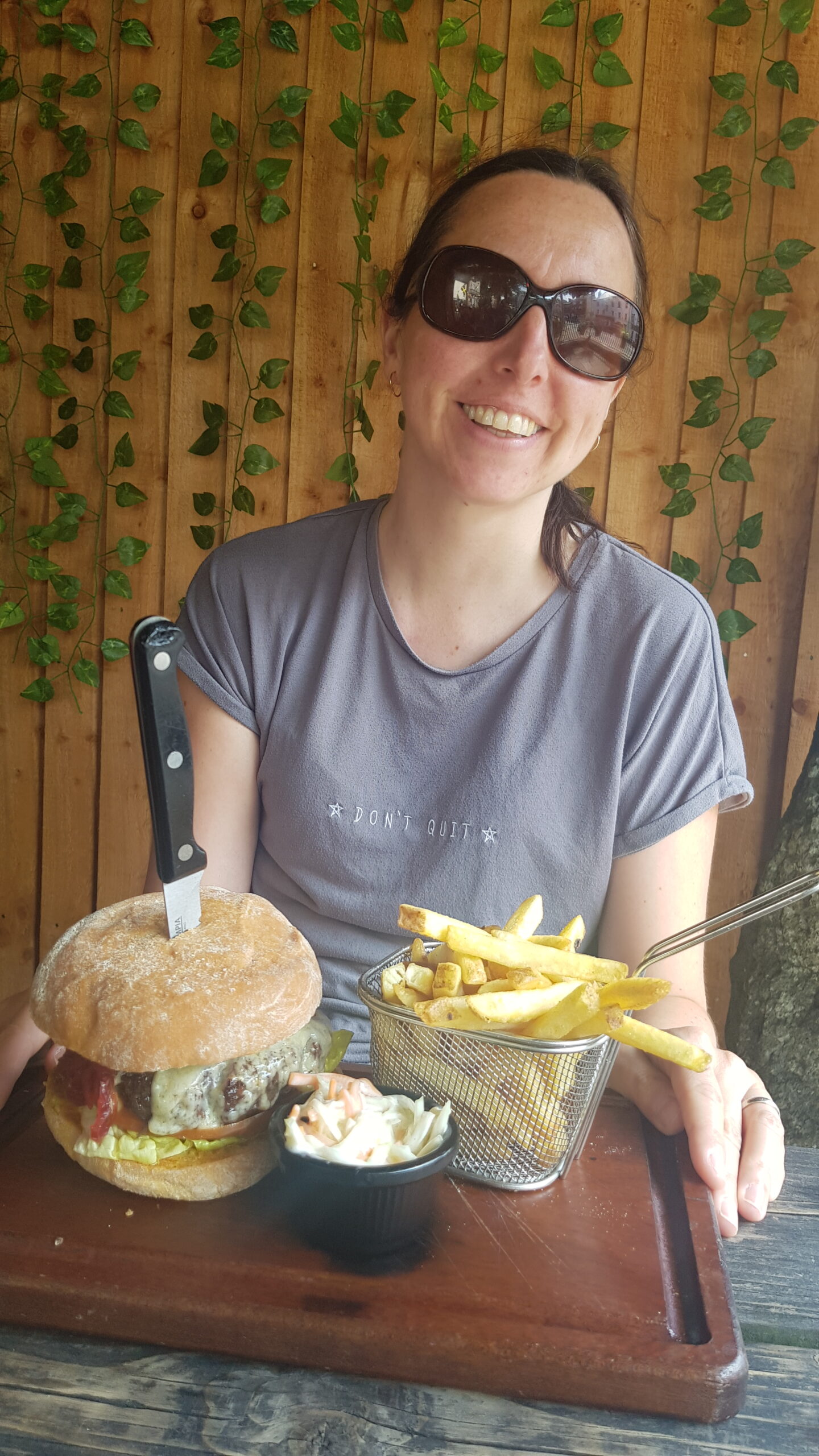 Eating out. Big burger and fries on a board.