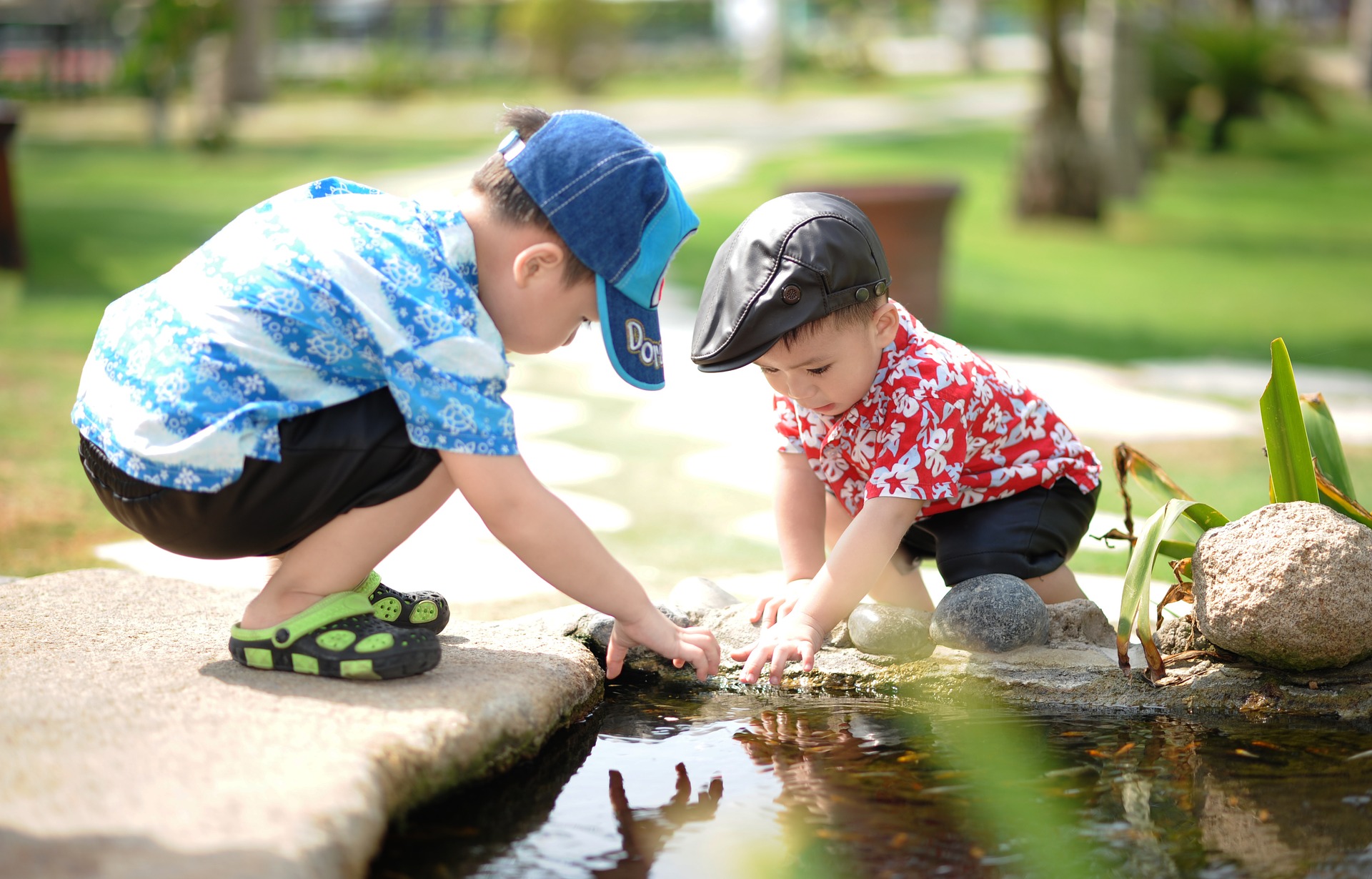 Two children playing looking over a pond for social skills