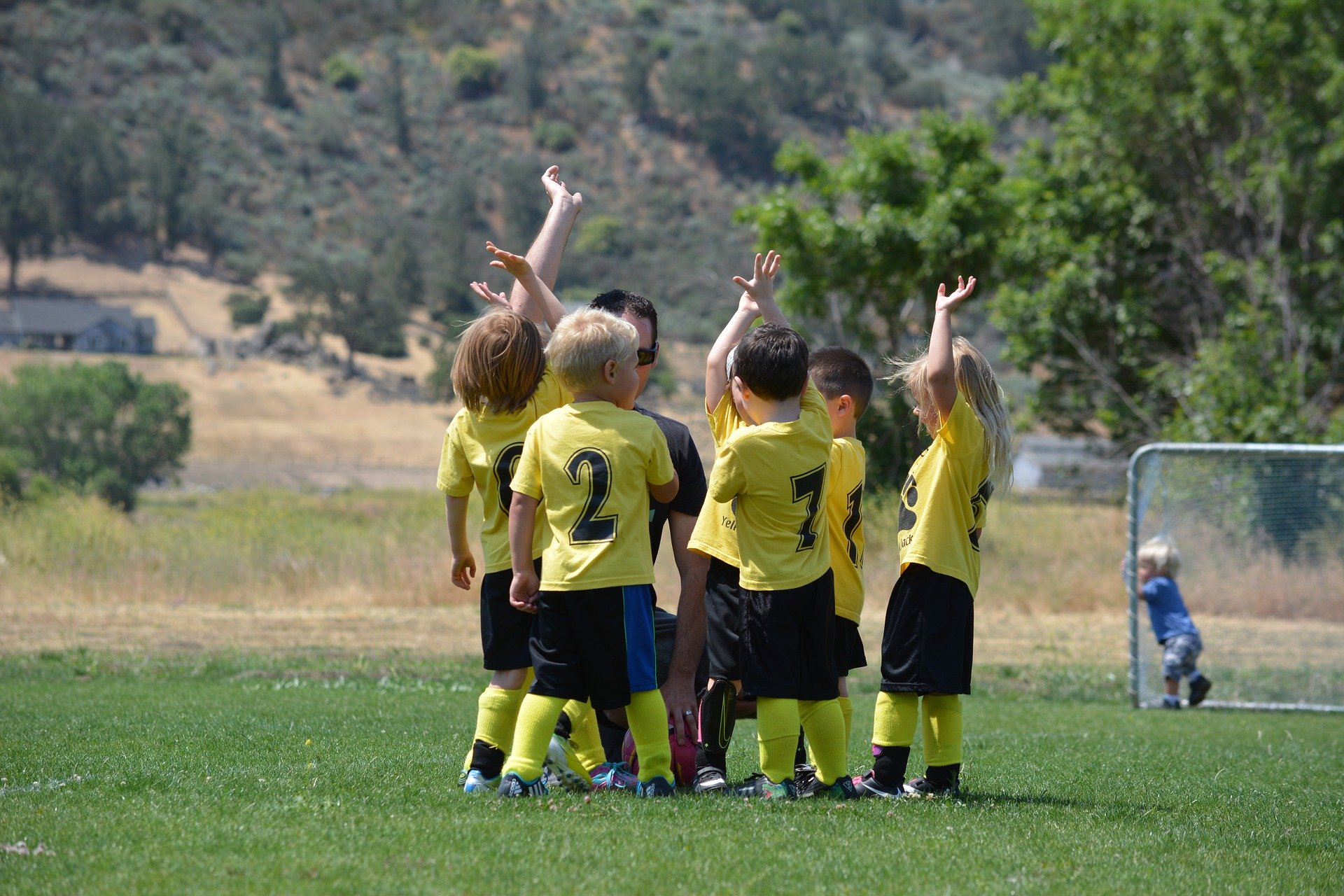Children on a football field playing as a Sports Team